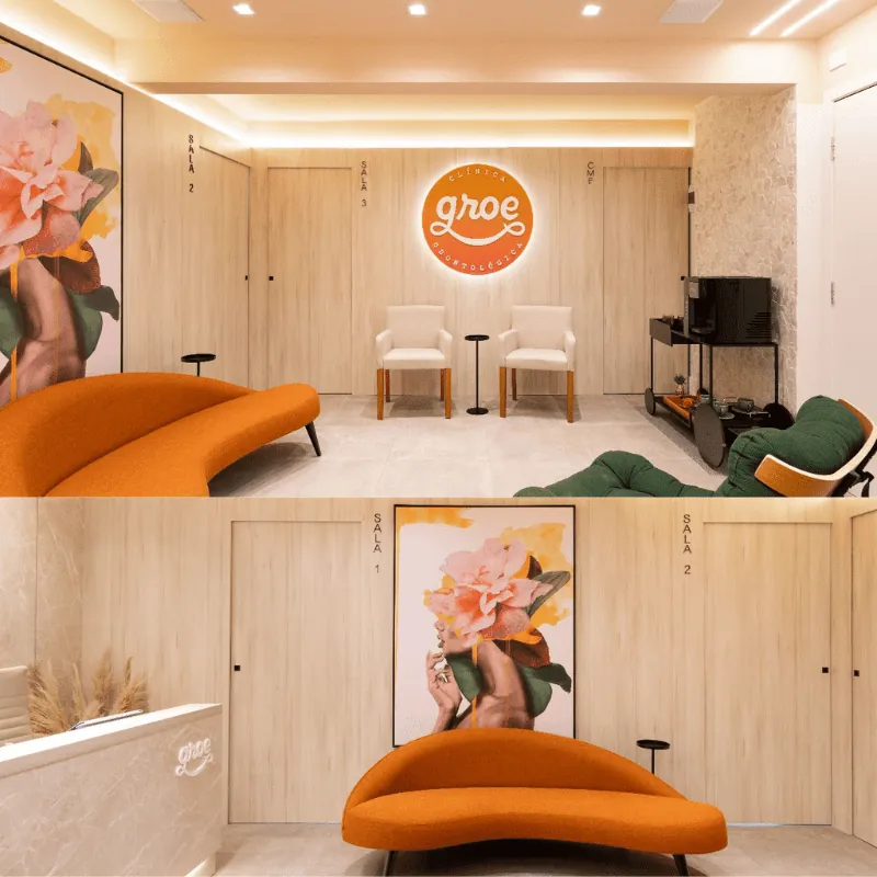 Sala de espera da Clínica Groe, com sofá laranja e logotipo iluminado